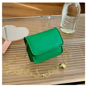 Detail of lime green mini bag featuring a gold chain strap with adjustable metal ball