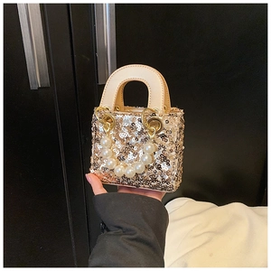 Close-up of gold sequins and pearl bead handle on a mini fashion handbag for girls
