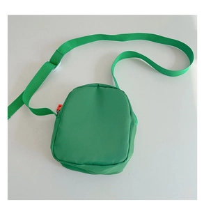 Detail view of mini green nylon crossbody bag for kids with adjustable shoulder strap