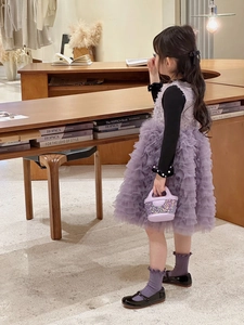 Fillette avec sac à main pailleté violet, robe en tulle et chaussures Mary Jane