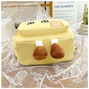 Detail of cute yellow backpack with plush chicken leg charms and eye embroidery