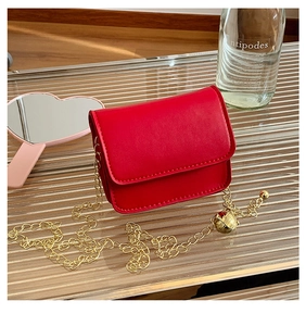 Close-up of red mini square bag with gold chain and unique earth charm detail