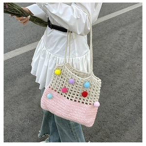 Close-up of hand-woven crochet tote bag with colorful pom-poms and fine mesh texture