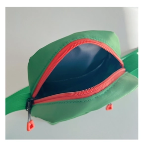 Detail view of mini nylon crossbody bag in bright green with contrast orange zipper and blue lining