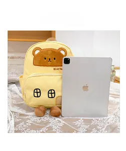 Cartoon bear house backpack in yellow compared with iPad Pro for size reference