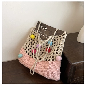 Detail of crochet shoulder bag with colorful pom-poms and ivory mesh weave design