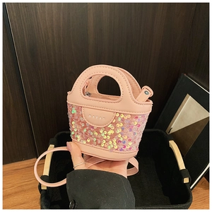 Détail d'un mini sac rose à paillettes pour enfants avec plaque en métal et bandoulière