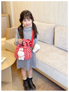 Detailed view of red and white checkered girls handbag with a 3D plush bunny decoration
