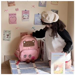 Detail of pink canvas toddler backpack featuring 3D brown bear and house window motifs