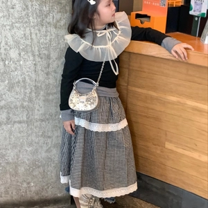 Girl's French style outfit with black top, checkered lace skirt, and silver sequin bag