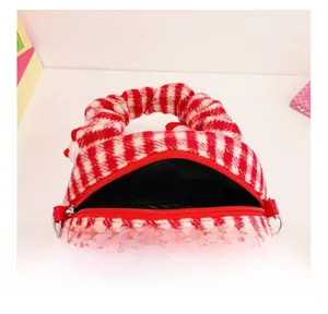 Detail view of red and white checkered plush bag showing zipper and black fabric lining