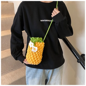 Détail du sac à bandoulière ananas crocheté à la main avec feuilles vertes et petites fleurs