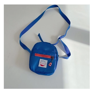 Detail of blue nylon kid cross-body bag with Sunny patch and orange zipper puller