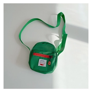 Detail of green nylon mini crossbody bag with a red zipper pocket and adjustable strap