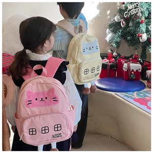 Zaini per bambini con gatti rosa e beige esposti in una calda ambientazione festiva