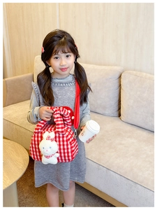 Detail of red checkered plush girl's handbag featuring a cute white bunny and thin strap