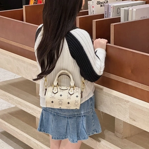 Child mini cylinder handbag with bear prints and adjustable strap in a library setting