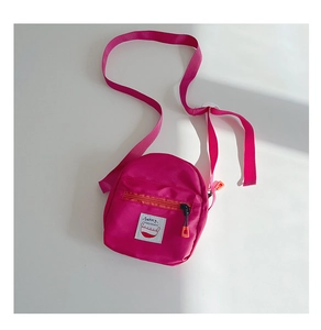 Detailed view of kids' rose red mini crossbody bag with Sunny patch and orange zipper