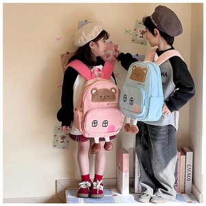 Detail view of pink and blue kids backpack with 3D cartoon bear and side pockets