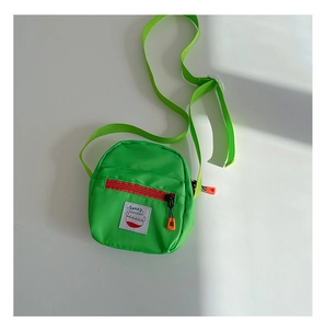 Detail of green kids crossbody bag with red zipper pocket and Sunny Kids label