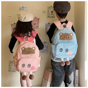 Detail of cute cartoon bear backpack with plush legs on children in a school setting