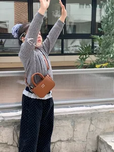 Détail du mini sac carré en cuir marron pour enfant avec fermoir en métal et poignée