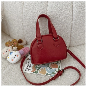 Detail of red shell-shaped mini handbag with lychee pattern on soft fleece background