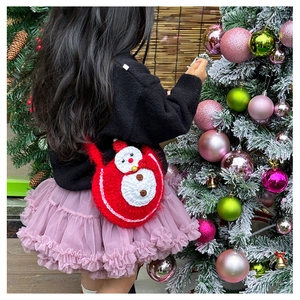 Vue de dos d'un enfant portant un sac à bandoulière bonhomme de neige en crochet rouge