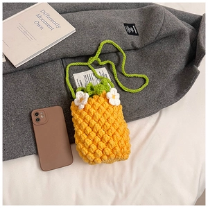 Détail du sac bandoulière ananas tricoté jaune avec feuilles vertes et fleurs blanches
