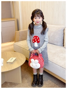 Detail of a gray knitted girls' dress with red polka dot mushroom and plush bunny bag