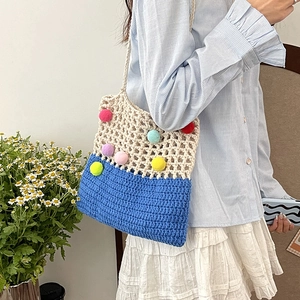 Handmade crochet hollow tote bag with colorful pom-poms and blue base for beach or casual use