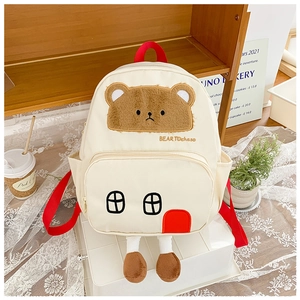 Detail of cute bear backpack for kids with house-shaped pocket and plush doll legs