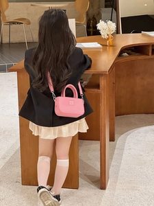Détail du mini sac à bandoulière rose pour enfant avec poignée fixe et sangle réglable