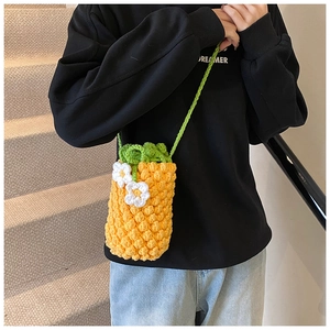 Détail du sac bandoulière ananas crocheté main avec texture 3D et sangle en feuilles