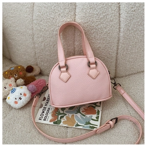 Detailed view of pink shell-shaped crossbody bag with lychee texture and thin strap