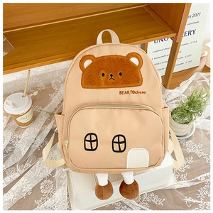 Detail of cute bear embroidery and house-shaped design on a beige toddler backpack