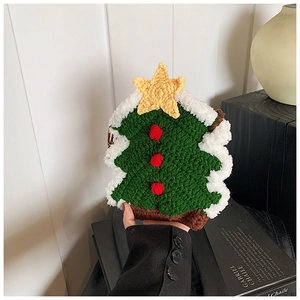 Gros plan détaillé d'un sac sapin de Noël tricoté main avec pompons rouges et étoiles