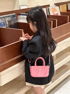 Détail du mini sac bandoulière rose pour enfant avec texture gaufrée et poignée haute
