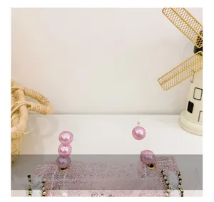 Close-up of pink tweed girl handbag with lace trim and elegant pearl bead handle