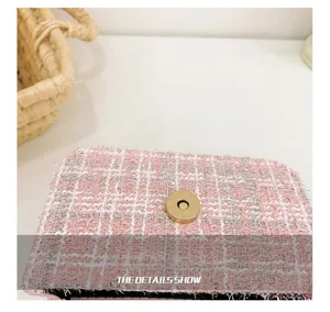 Close-up of pink tweed girl's bag texture with gold magnetic clasp detail