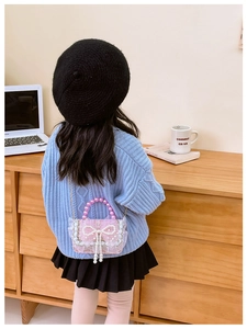 Pink sequin bag for girls with large pearl bow and lace trim details shown on model