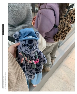 Detailed plush texture of leopard print bear backpacks with denim hats and nylon straps