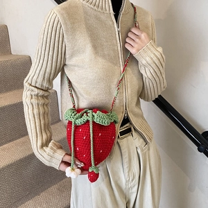Handmade crochet strawberry crossbody bag with white flower decor and drawstring closure