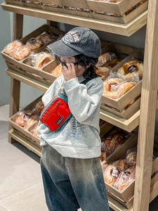 Détail d'un enfant portant un sac de poitrine rouge et bleu tendance au style urbain
