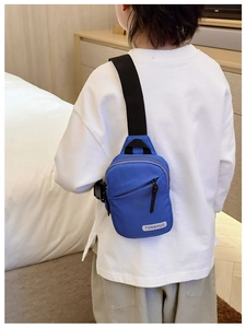 Detail of adjustable black strap and buckle on blue nylon crossbody chest bag for kids