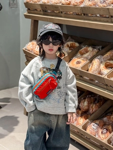 Sac de poitrine extérieur rouge et bleu pour enfants porté par un mannequin stylé