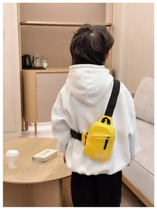 Macro detail of kids crossbody chest bag showing yellow nylon fabric and black zipper