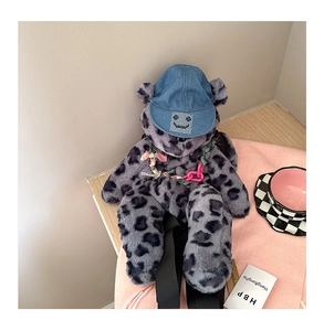 Close-up of leopard plush backpack with denim bear hat and rhinestone smiley face