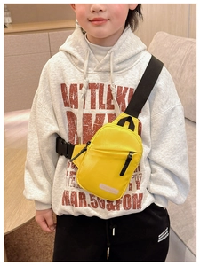 Close-up of bright yellow nylon kids crossbody chest bag with adjustable black strap