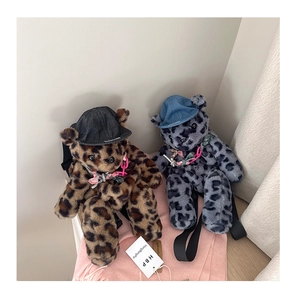 Detail of plush leopard print bear backpack showing denim hat and adjustable nylon straps